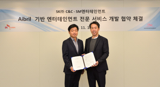 SK주식회사C&C는 14일 SM엔터테인먼트와 '에이브릴 기반 엔터테인먼트 전문 서비스 개발 협약'을 체결했다. 이기열 SK주C&C 디지털·금융사업부문장(왼쪽)과 김영민 SM엔터테인먼트 대표가 기념촬영을 하고 있다.  SK주식회사C&C 제공